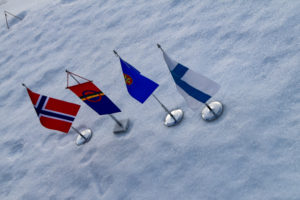 Norsk, samisk, kvensk, og finsk flagg på snø.